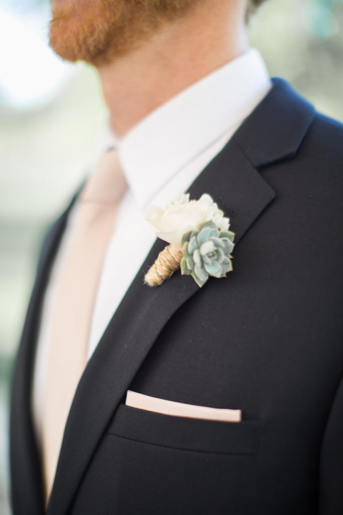 groom in black suit with pink tie and succulent boutonniere 