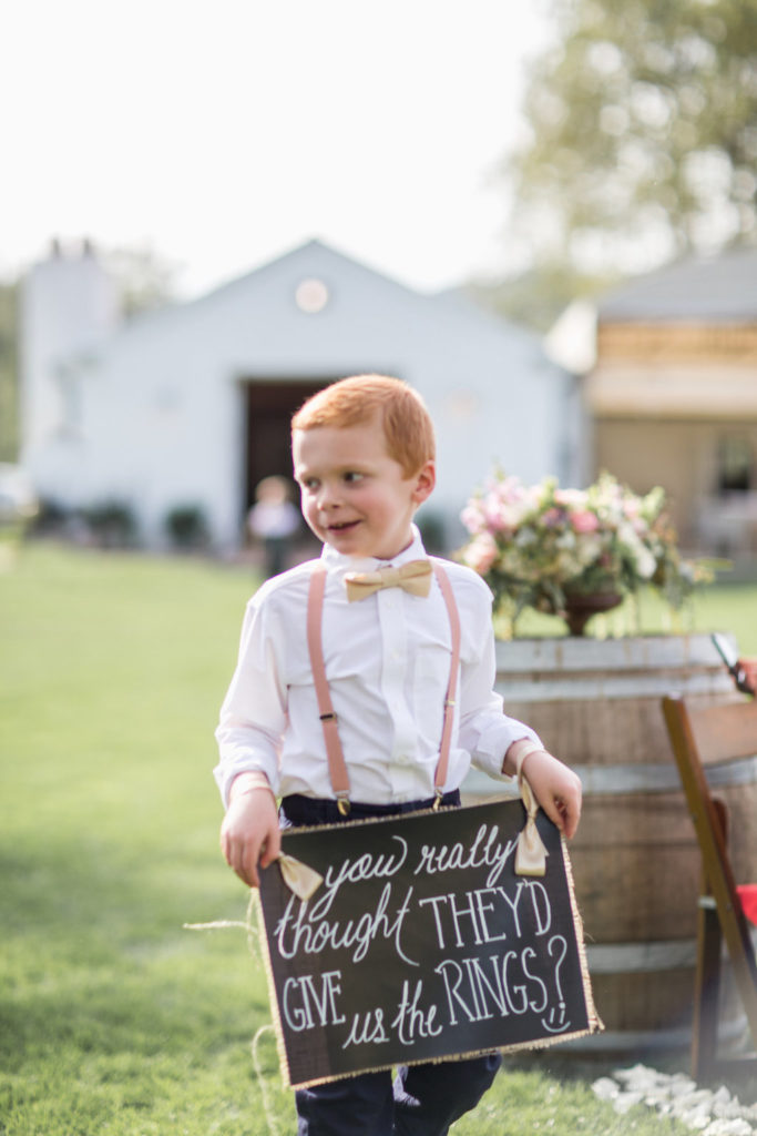 small wedding ceremony with ring bearer holding chalkboard sign