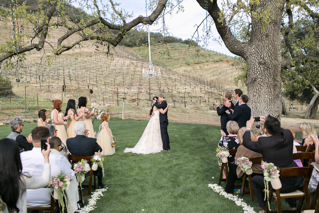 bride and groom first kiss during A sweet, small wedding ceremony at Triunfo Creek Vineyards
