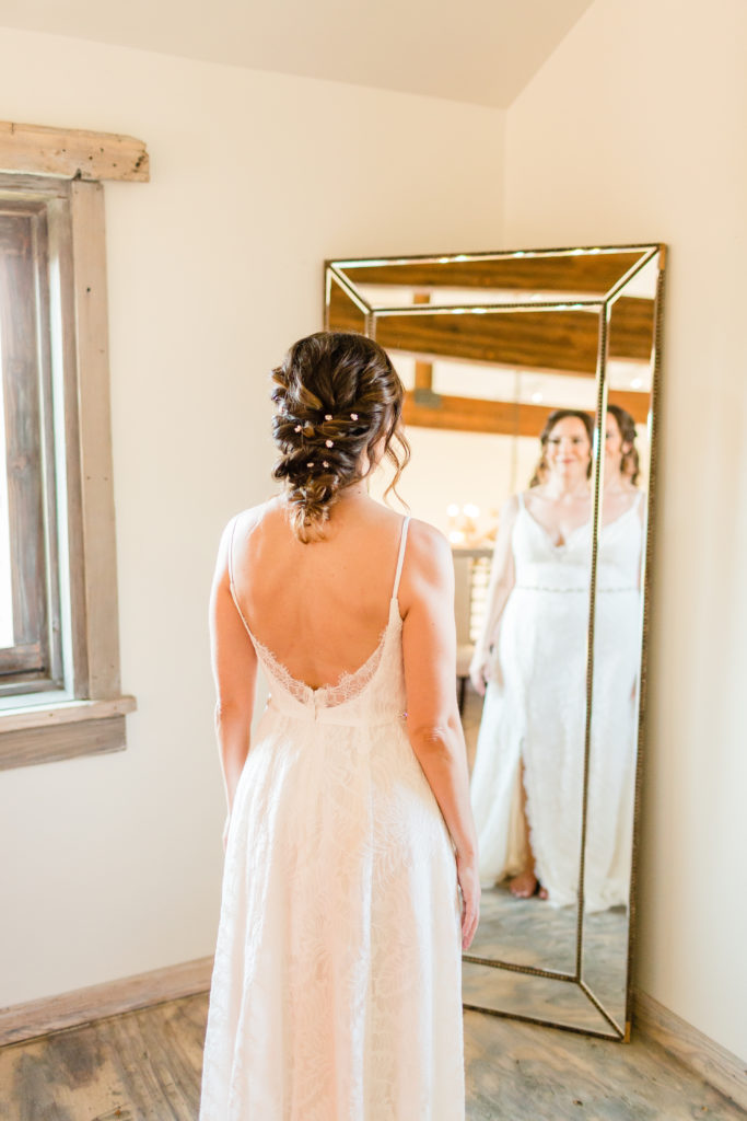 bride looking in mirror before her wedding day