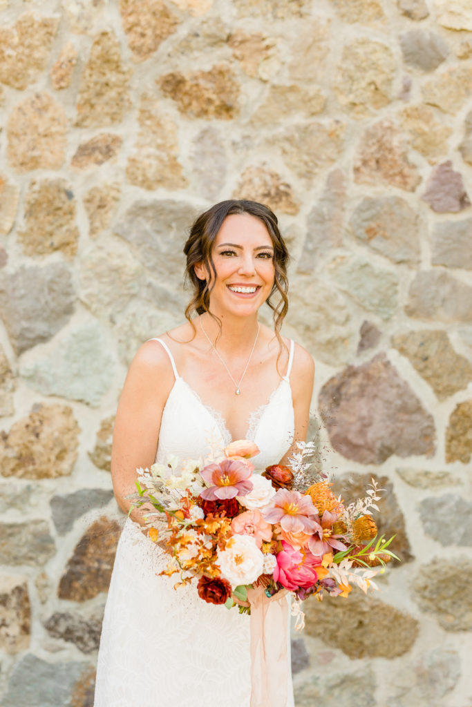 bridal portrait shot with fall themed bridal bouquet and spaghetti strap wedding dress