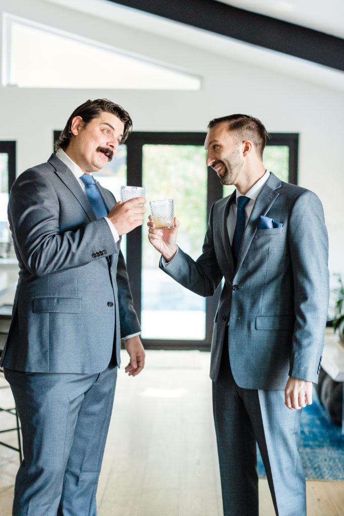 groom getting ready for wedding day wearing grey suit with blue tie