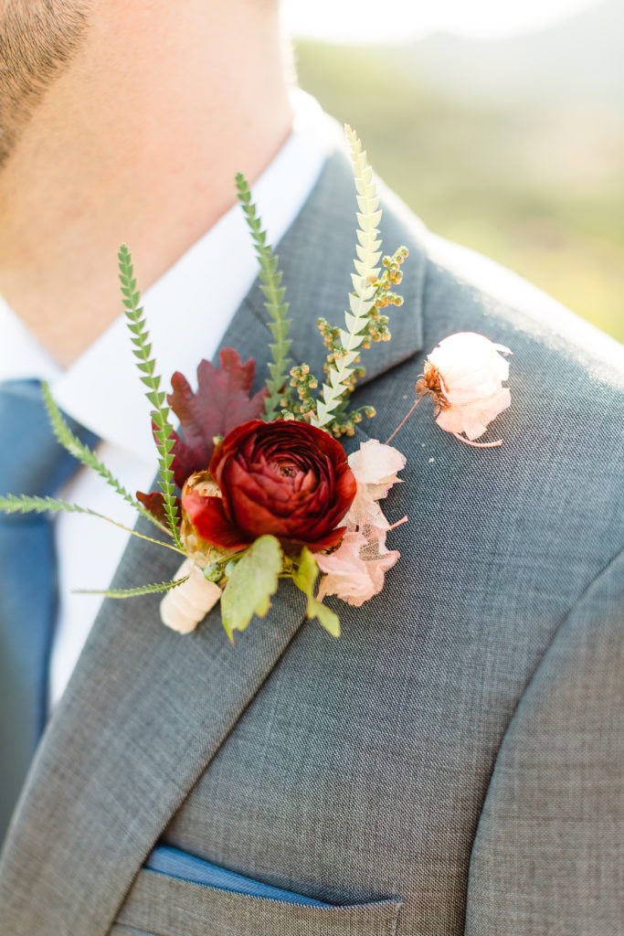 groom boutonniere with dark red and soft pink
