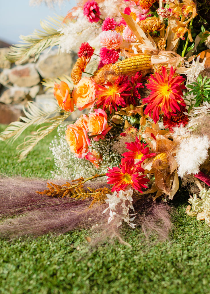 non-traditional micro wedding arch with fall themed flowers and corn