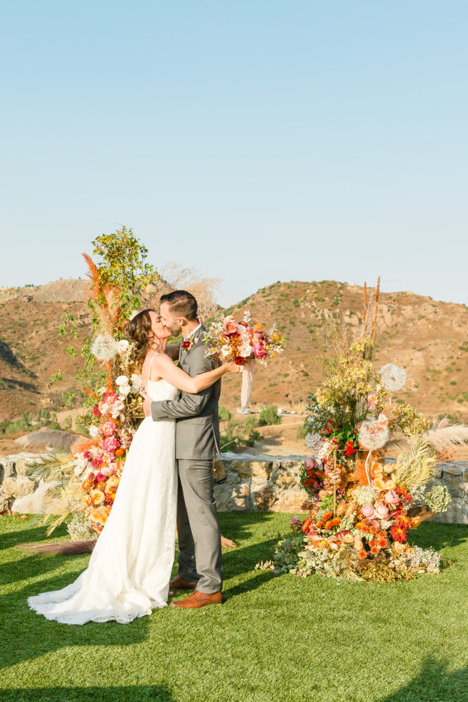 bride and groom first kiss during micro wedding ceremony at Cielo Farms