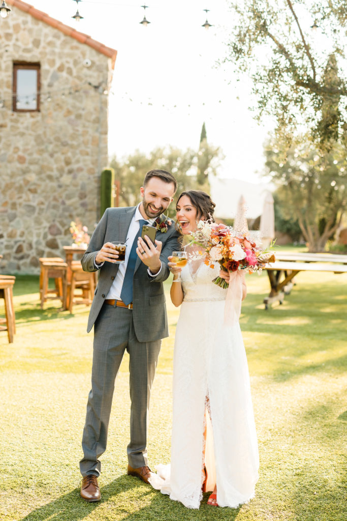 bride and groom FaceTime family after wedding at Cielo Farms