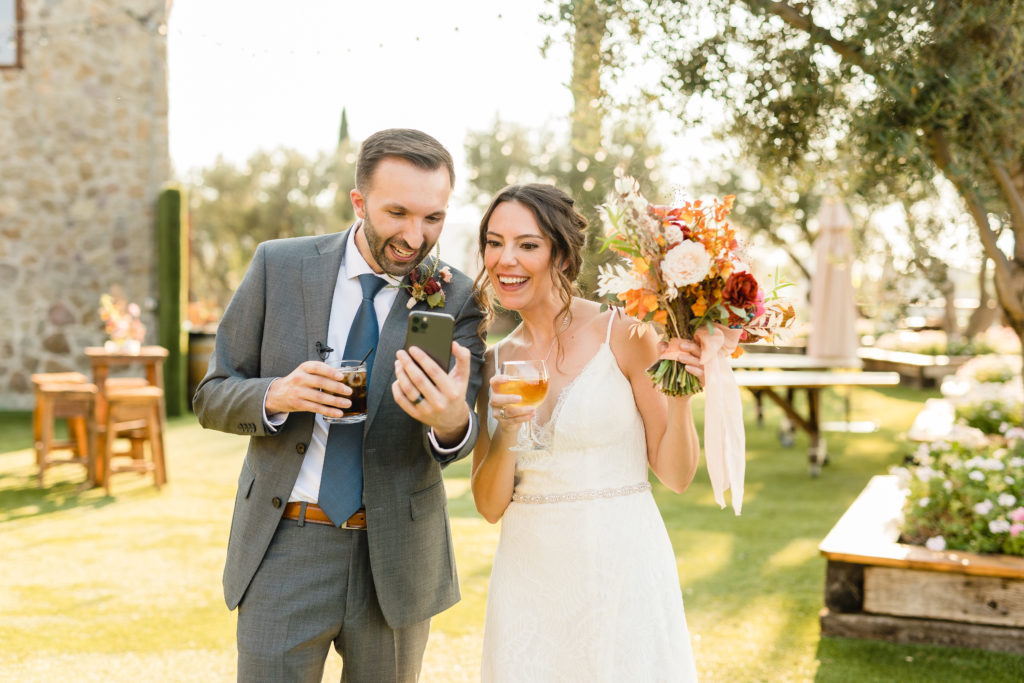 bride and groom FaceTime family after wedding at Cielo Farms