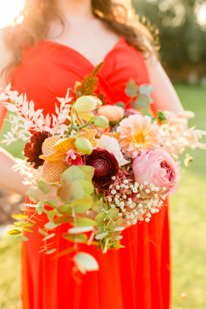 red bridesmaid dress with fall themed bouquet