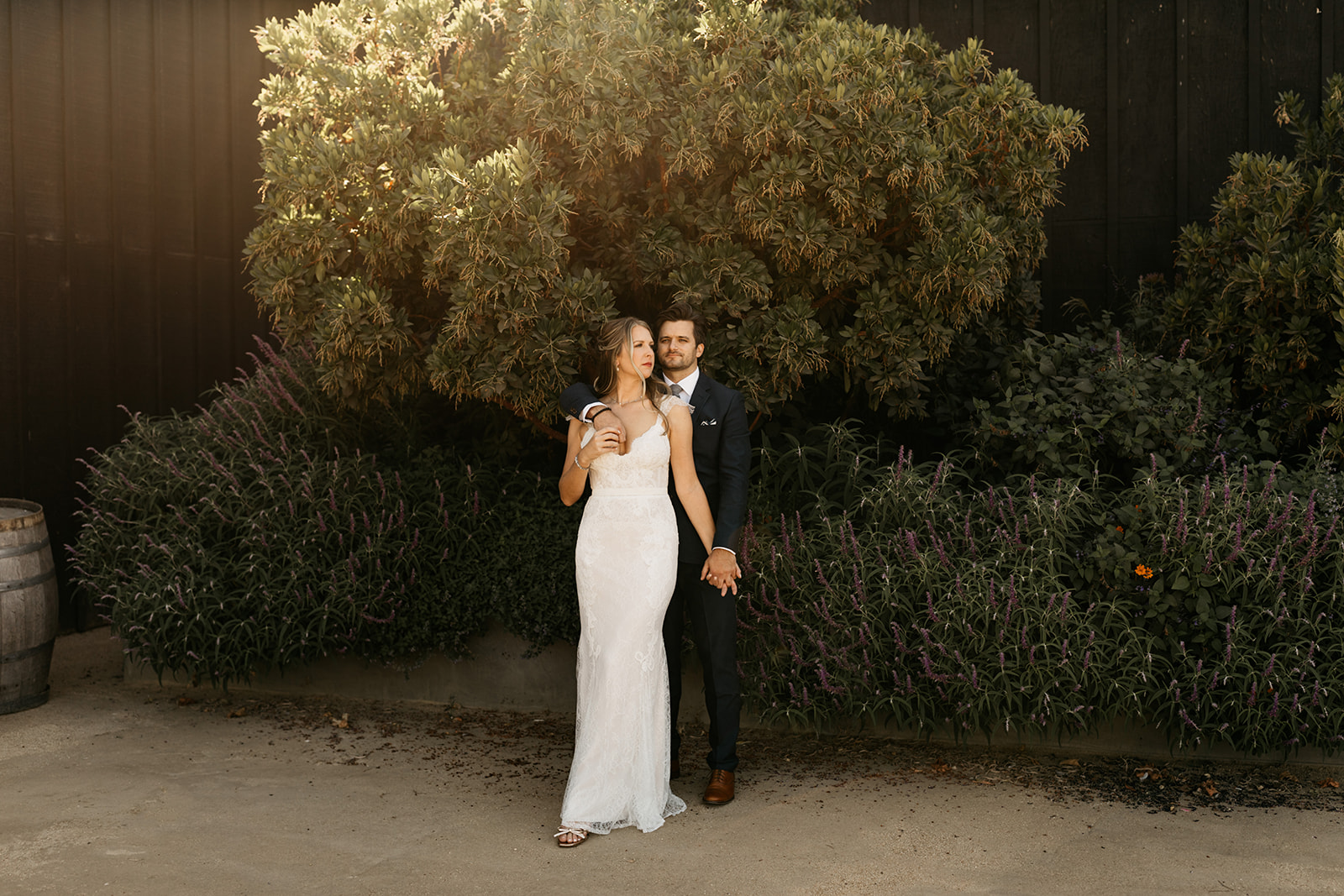 bride in lace dress with groom in dark blue suit portrait shot at Roblar Winery