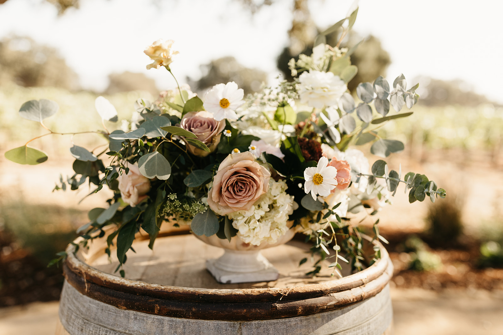 wine barrels with floral arrangements for winery wedding