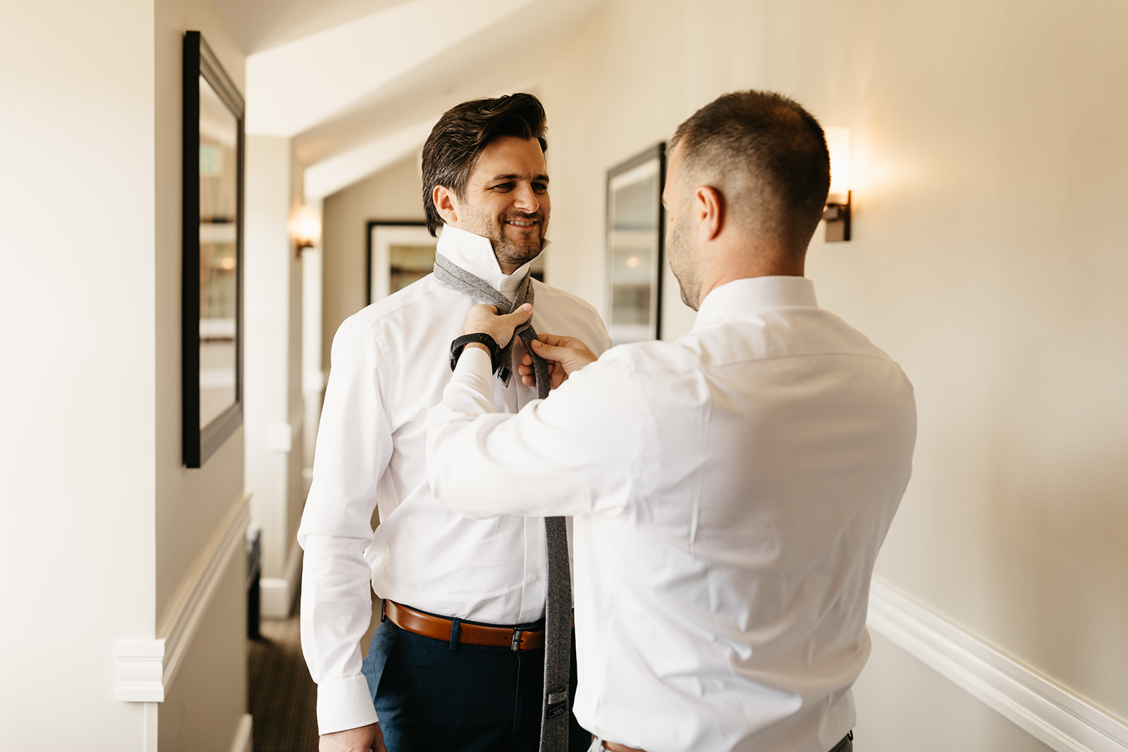 groom getting tie on with help from groomsman