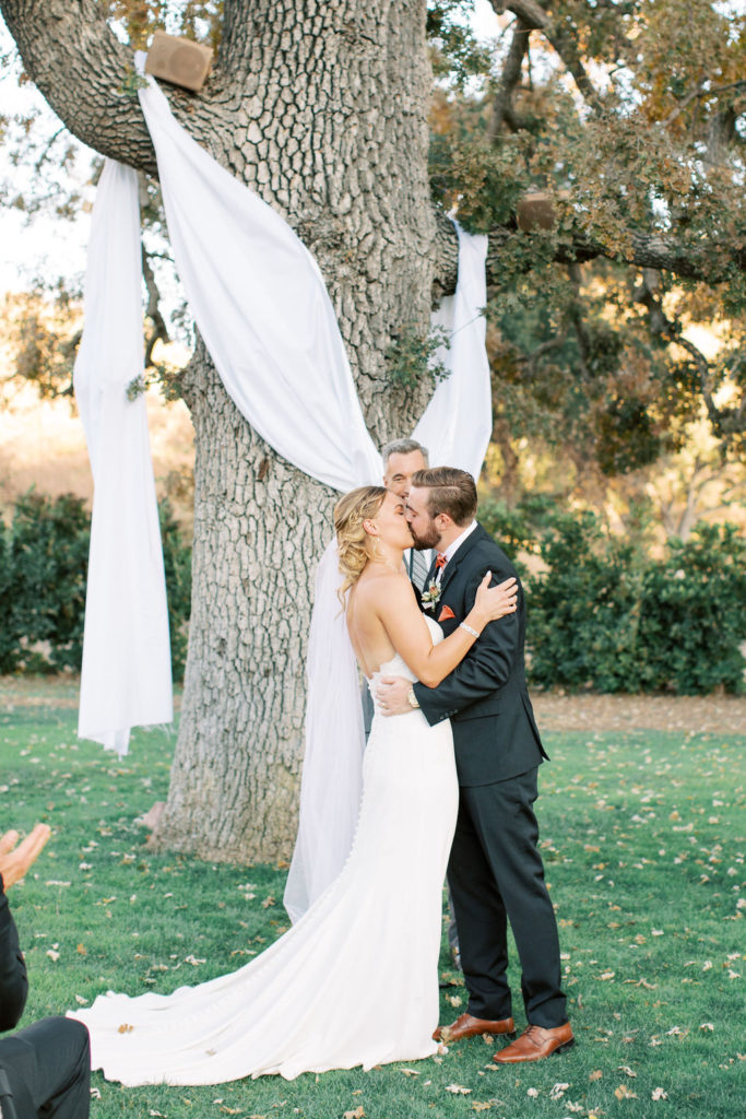 minimalist autumn wedding ceremony, bride and groom first kiss