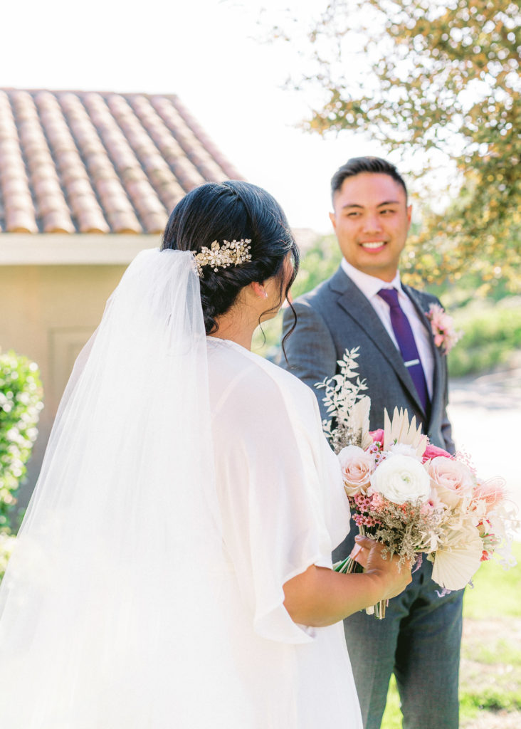 bride wearing Reformation wedding dress and groom with grey suit and purple tie portrait shot after their backyard ceremony