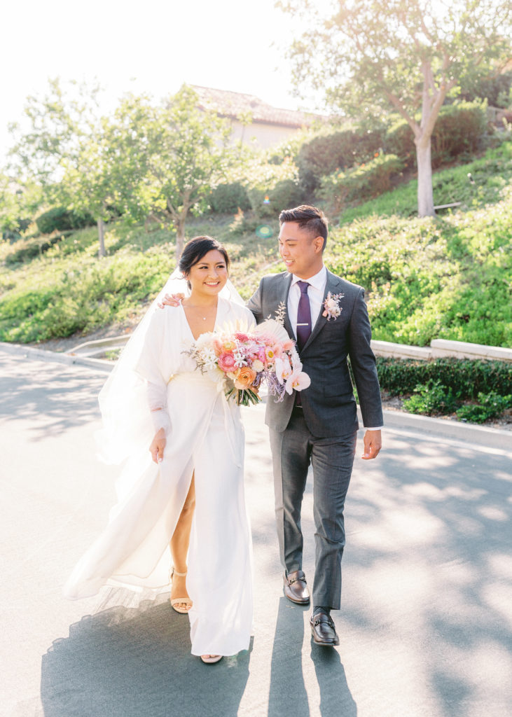 bride wearing Reformation wedding dress and groom with grey suit and purple tie portrait shot