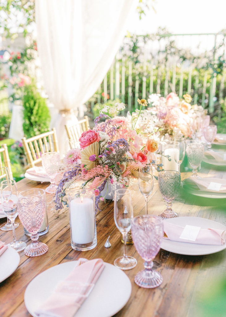 small backyard wedding reception with gold chivari chairs,  pink and purple floral centerpieces and acrylic place cards