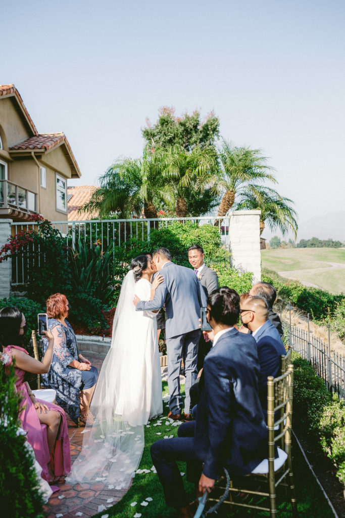 A small, backyard ceremony with a water fountain backdrop 
