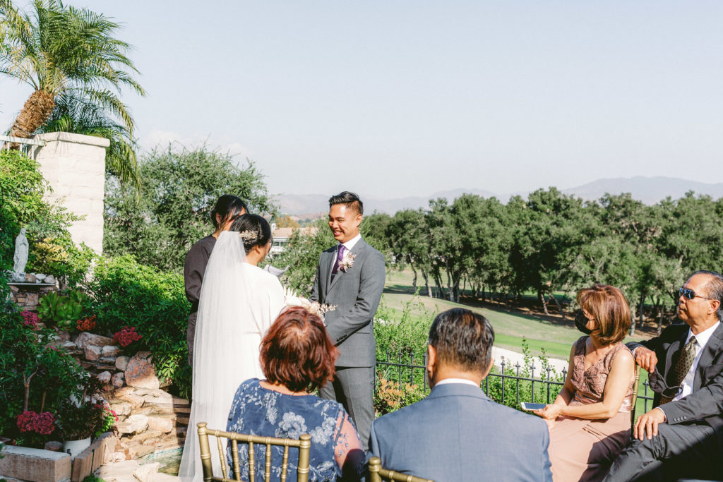 A small, backyard ceremony with a water fountain backdrop 