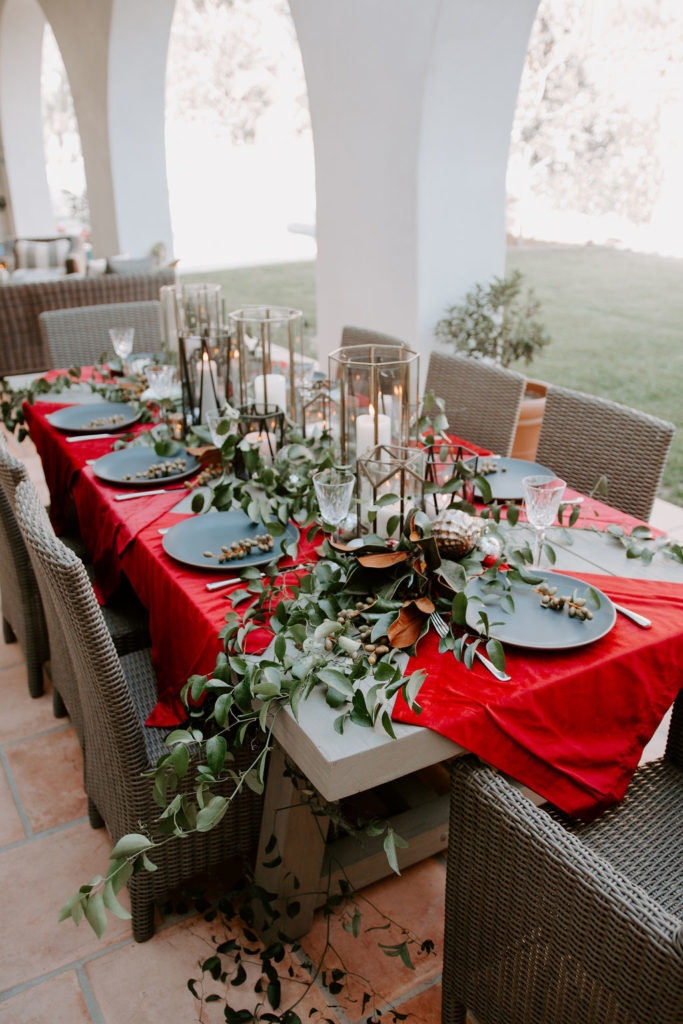 outdoor dining holiday table decorations with eucalyptus and magnolia leaves