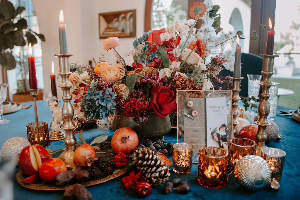 cozy non-traditional holiday decorations with a deep blue tablecloth and wild centerpiece with fruit