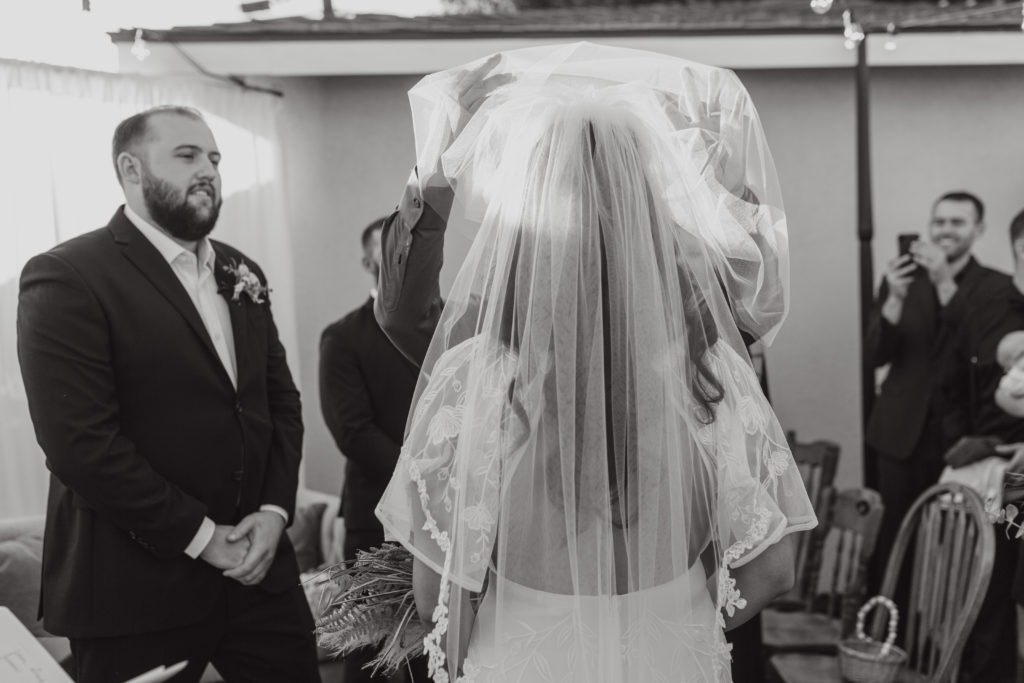 Father of the bride lifts veil during wedding ceremony