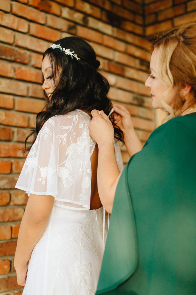 Bride getting ready with her mother for her intimate backyard wedding