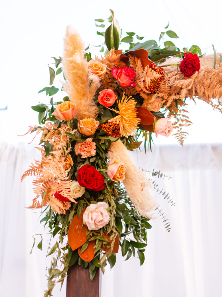 floral arch with pampas grass for this Bohemian style backyard wedding reception