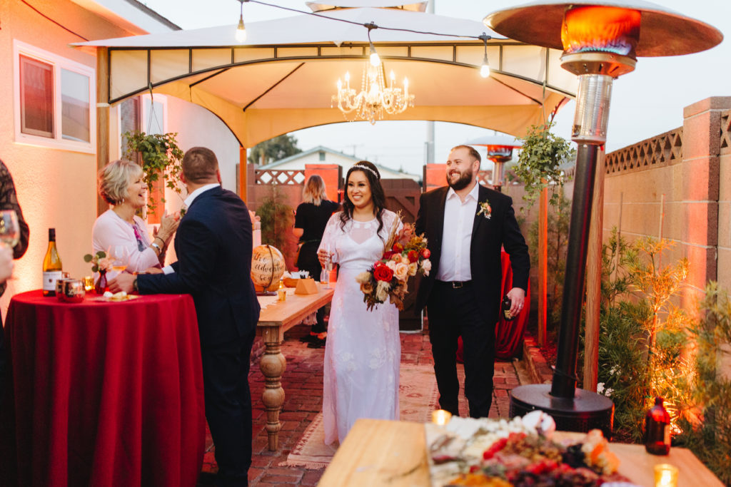 bride and groom enter cocktail hour for their small backyard wedding reception