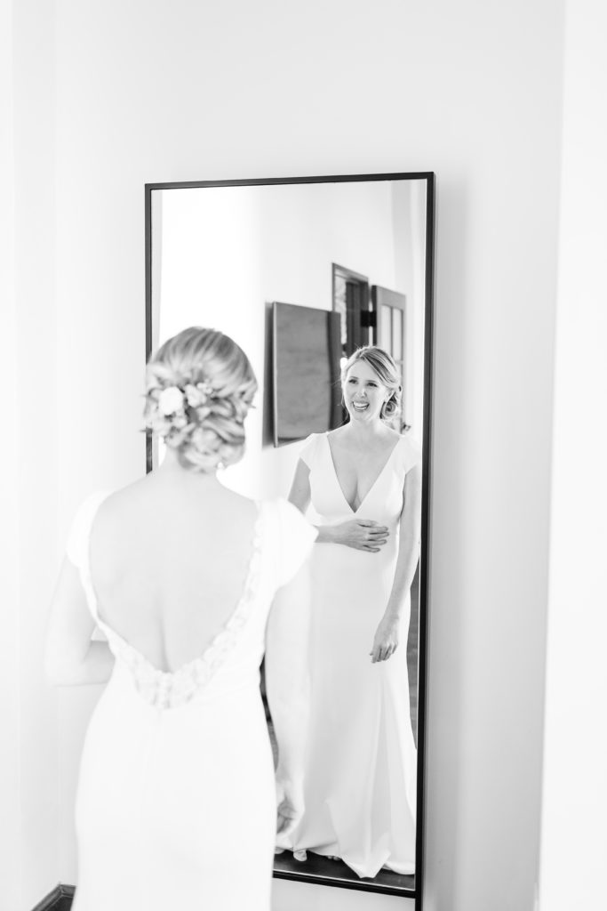 bride looking at herself in the mirror before her wedding