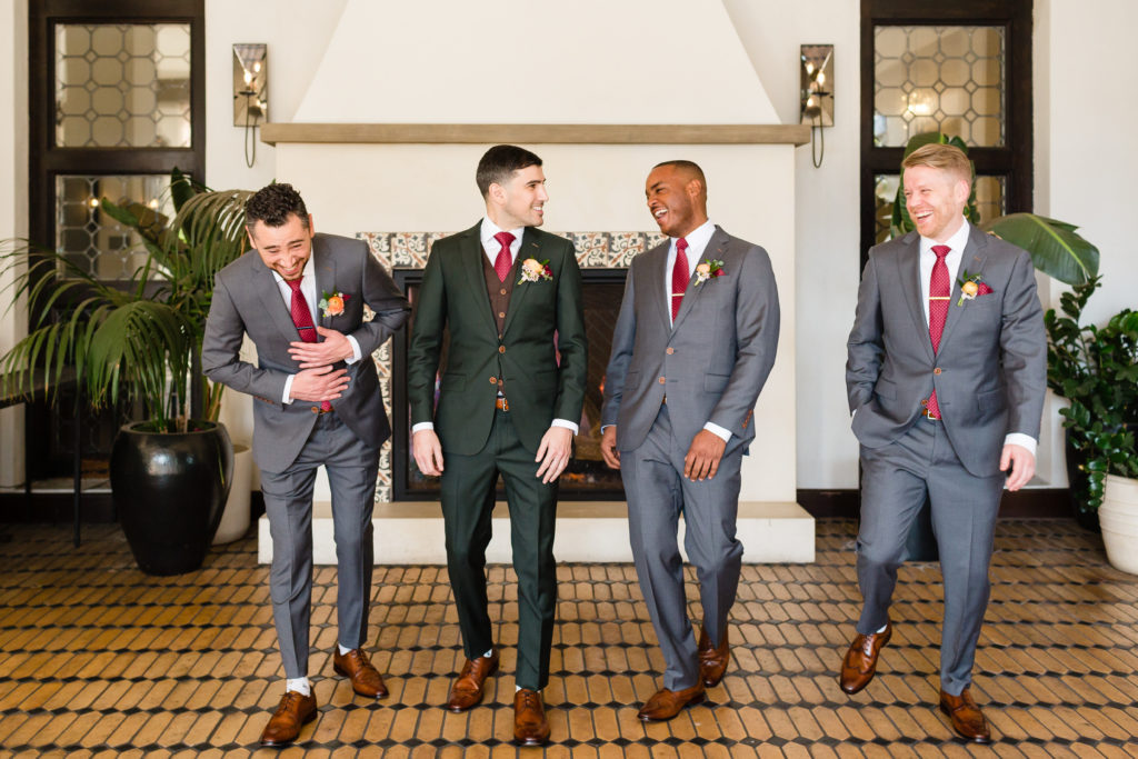 Groom with his groomsmen wearing dark grey suit and red tie getting ready for a spring wedding at Hotel Figueroa