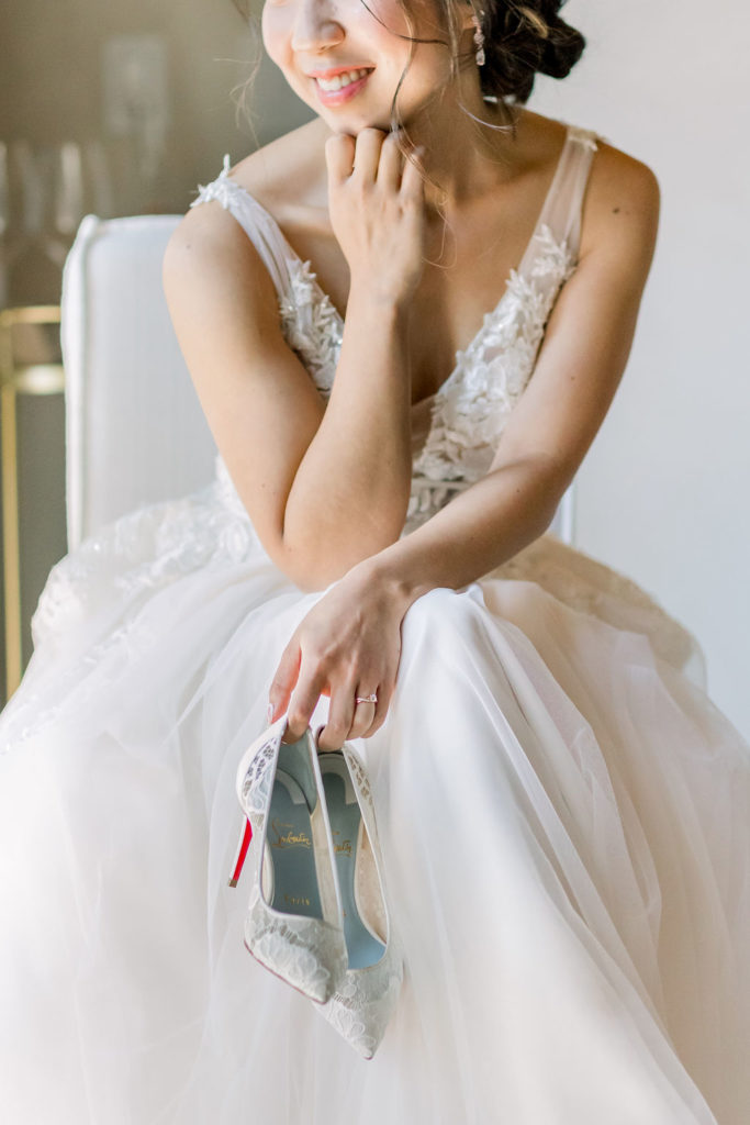 bride holding lace louboutin heels