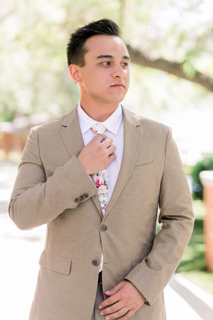 groom wearing tan suit with floral tie