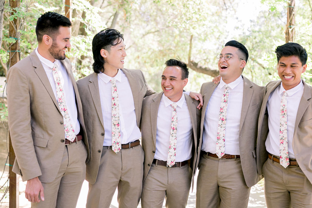 groom and groomsmen wearing tan suit with floral tie
