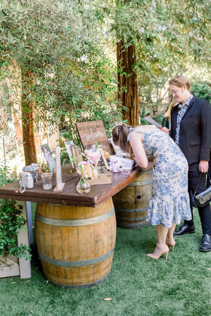 wedding guests sign guest book at welcome table