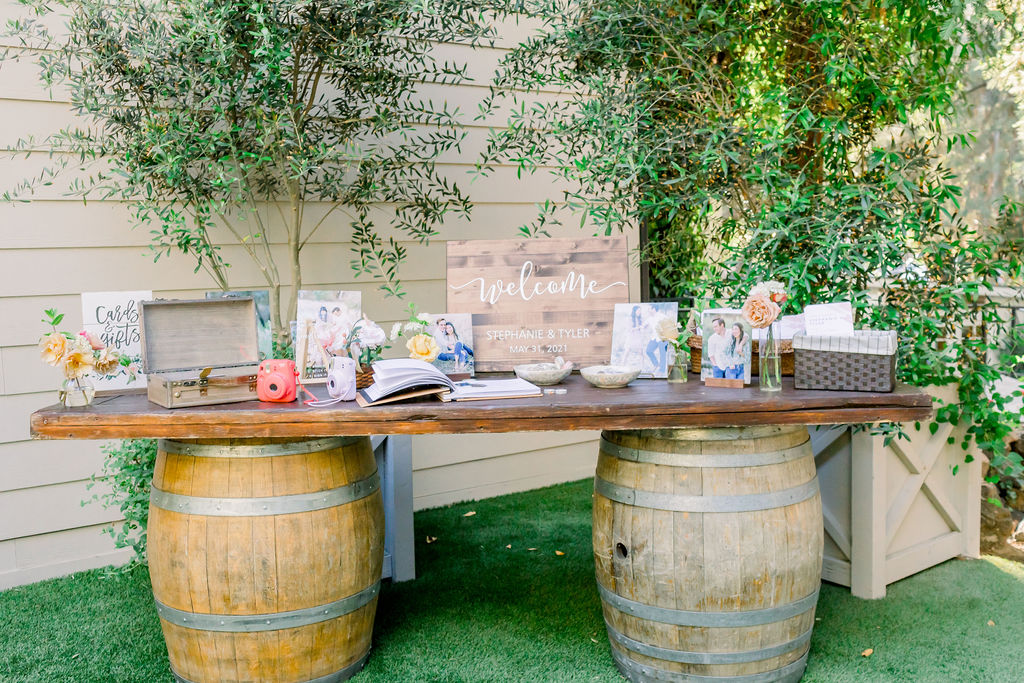wedding welcome table with wine barrels 