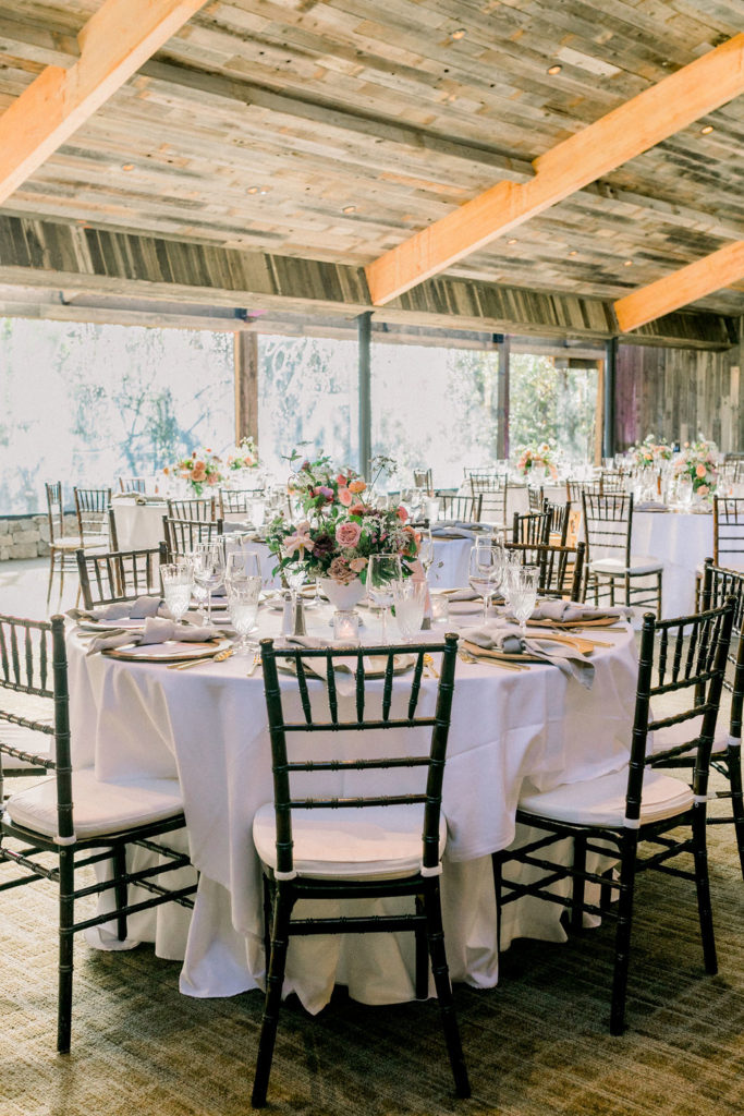 wedding reception tables at the Redwood Room at Calamigos Ranch with black chairs