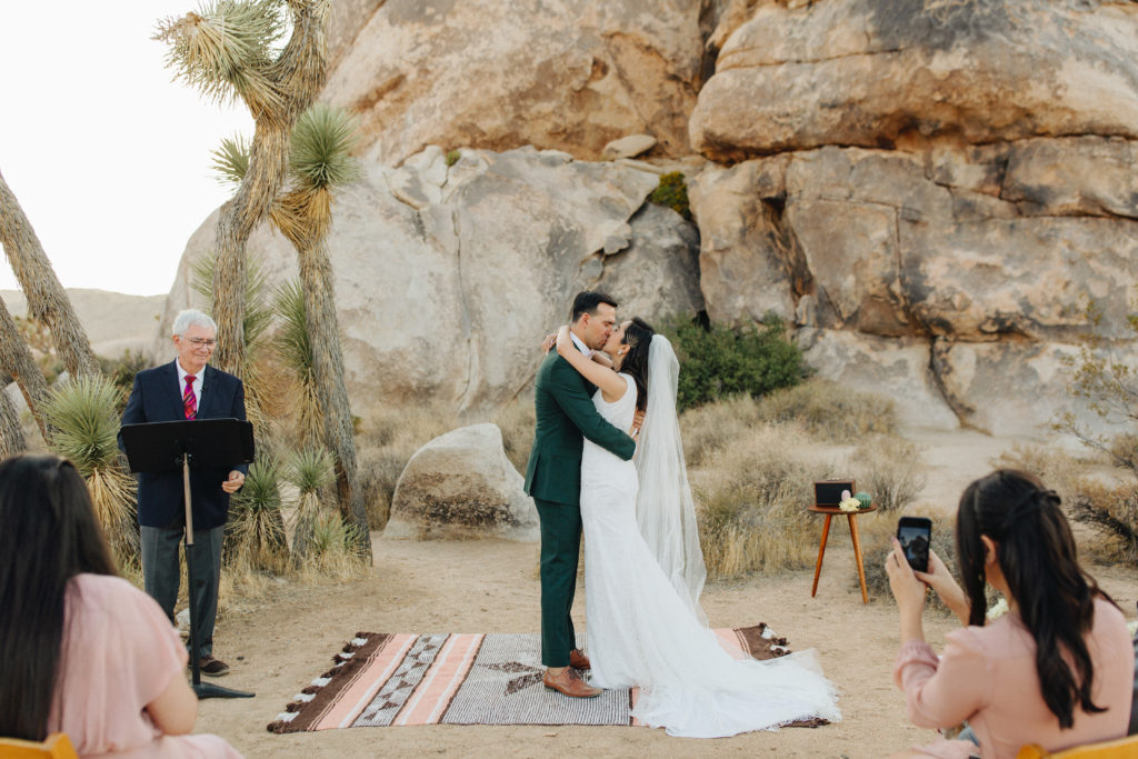bride and groom first kiss during Joshua Tree wedding ceremony 