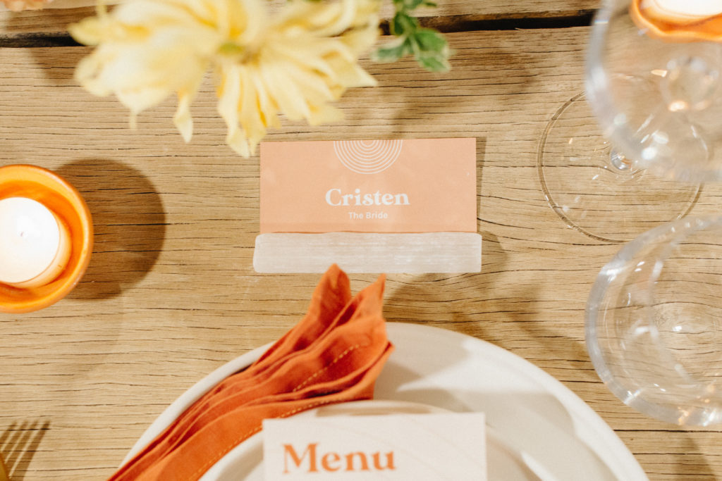 wedding reception in Joshua Tree for small guest count with bright orange, red and yellow tones and mid-century style menu