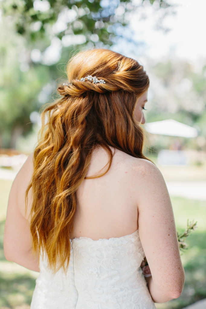 long bridal hair style with curls and a crystal hair piece