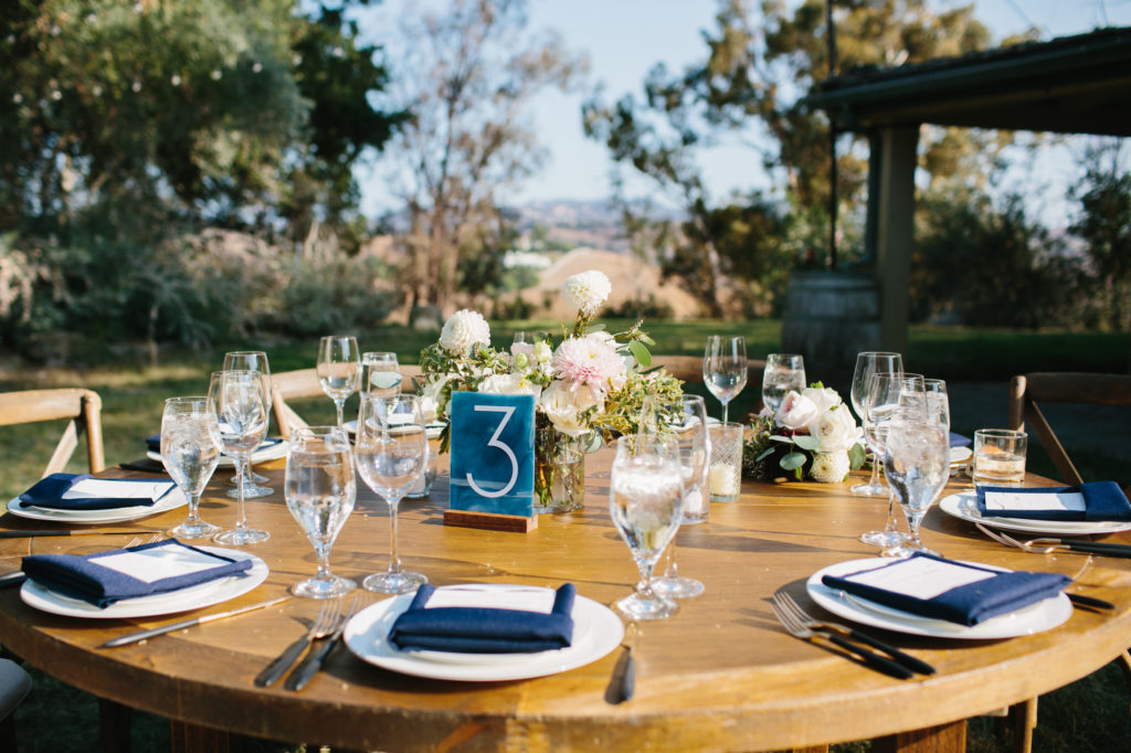 wedding reception in the Santa Monica Mountains with blue acrylic table numbers and blue napkins