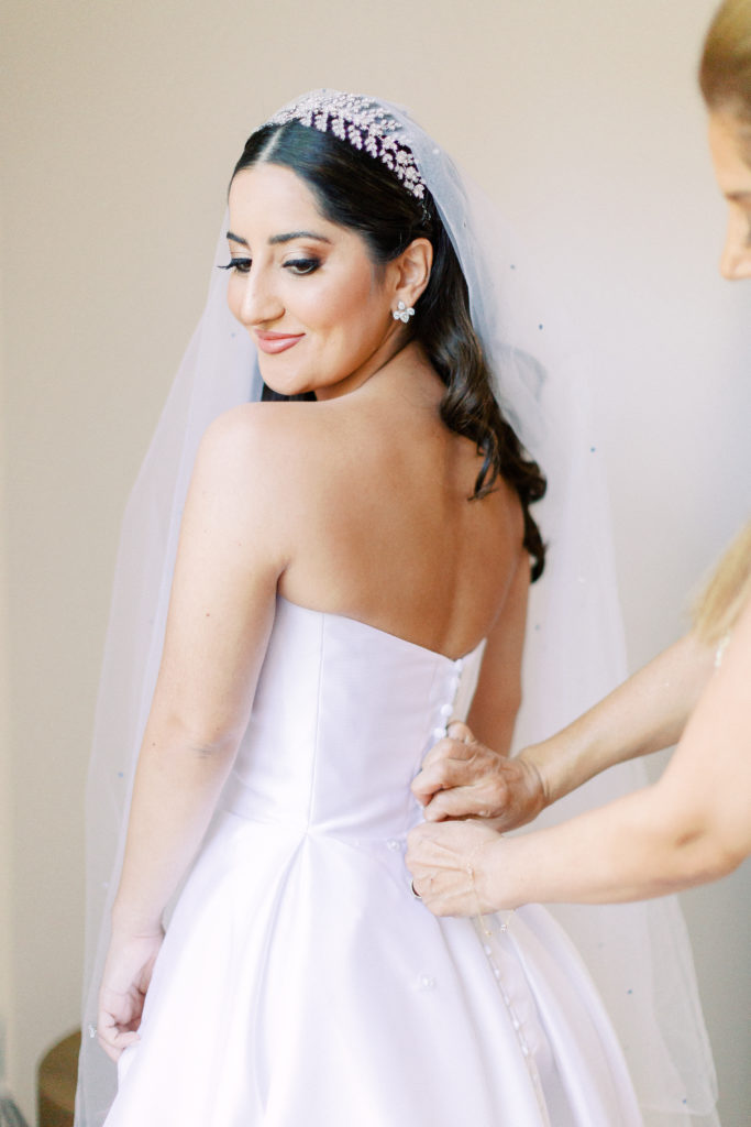 bride getting dressed in strapless ballgown