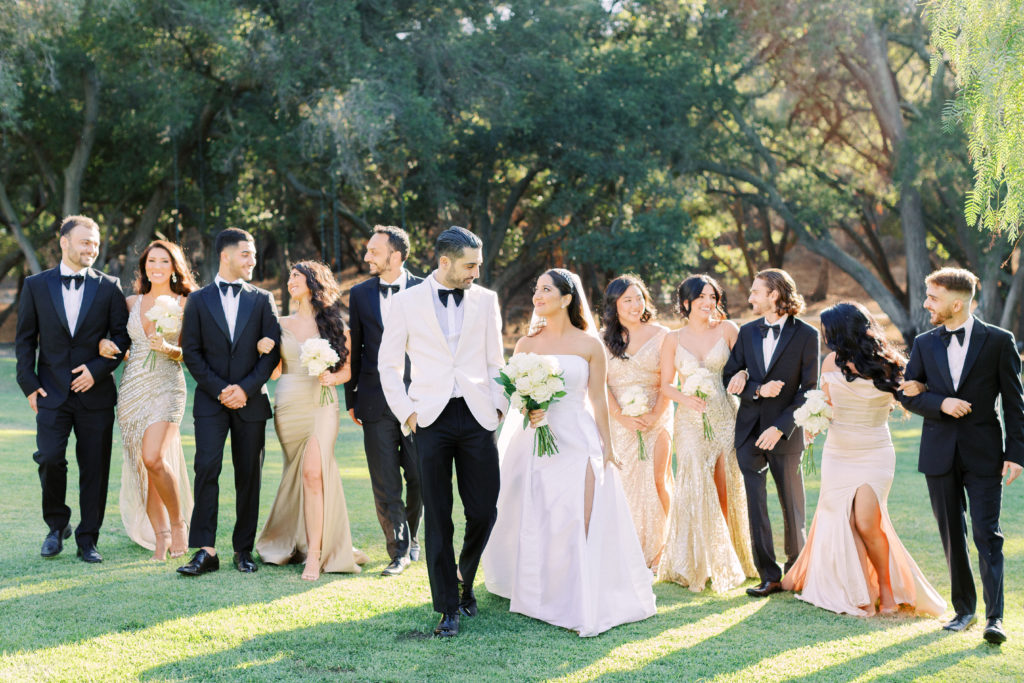 classic black tie wedding party with mix matched gold bridesmaid dresses and black groomsmen suits
