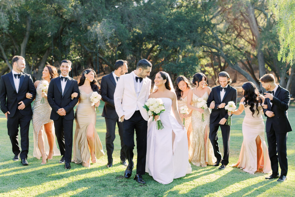 classic black tie wedding party with mix matched gold bridesmaid dresses and black groomsmen suits