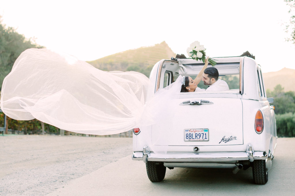 bride and groom portrait shots in vintage white car at Saddlerock Ranch