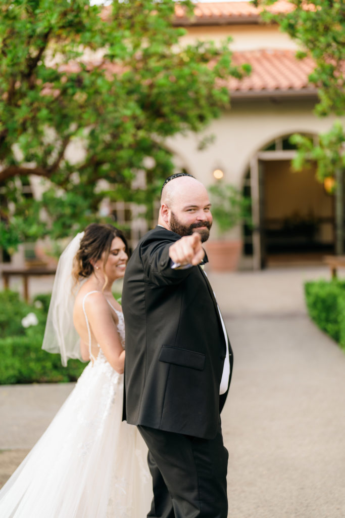 groom points to camera after wedding ceremony