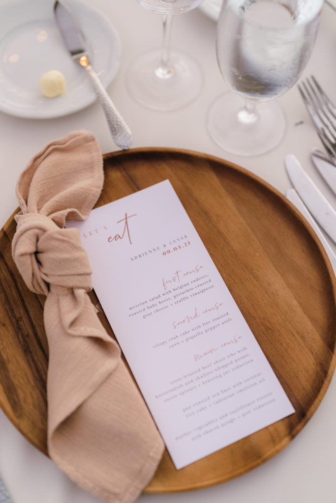 neutral palette wedding reception with wooden plate charger, beige linen napkin and menu