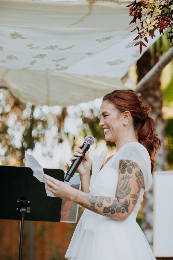 bride laughs while saying vows during wedding ceremony