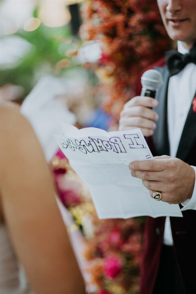 groom reads handwritten vows during wedding ceremony
