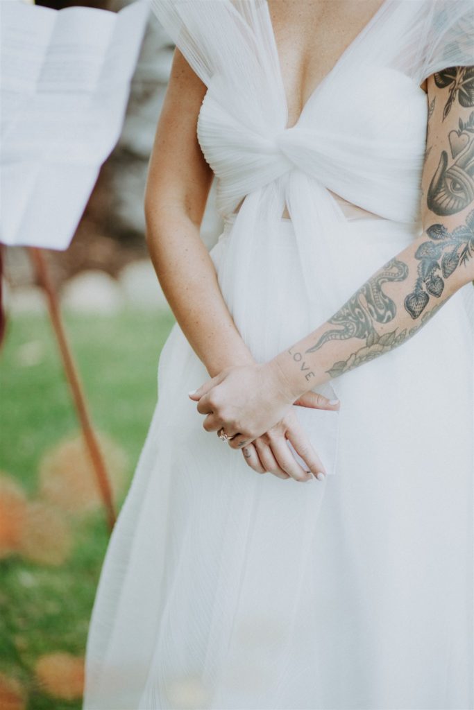 tattooed bride with the word "love" on her wrist