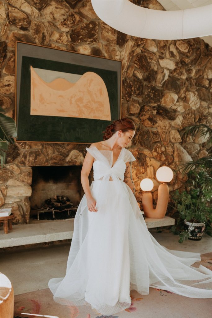 bride in modern asymmetrical dress stands in the Capri Hotel in Ojai