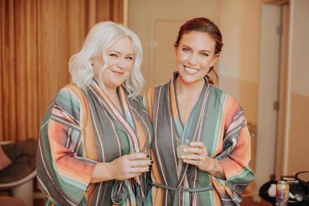bride with maid of honor in colorful striped robe